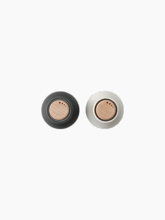Top-down view of two Bottle Grinders. The left is Carbon, the right is Ash, both with Beech lids.