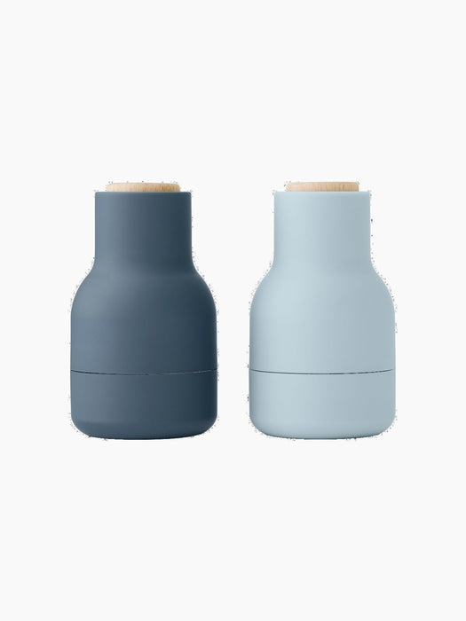 Two small Bottle Grinders with light wood Beach Lids, shown from the front. One is dark blue, the other is light blue.