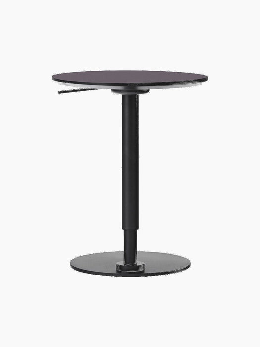Back view of the height-adjustable Branch Side Table showing its round charcoal top, black steel pedestal, and circular base.