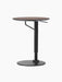 Angled view of the height-adjustable Branch Side Table with a dark round tabletop and black steel column with a flat base.