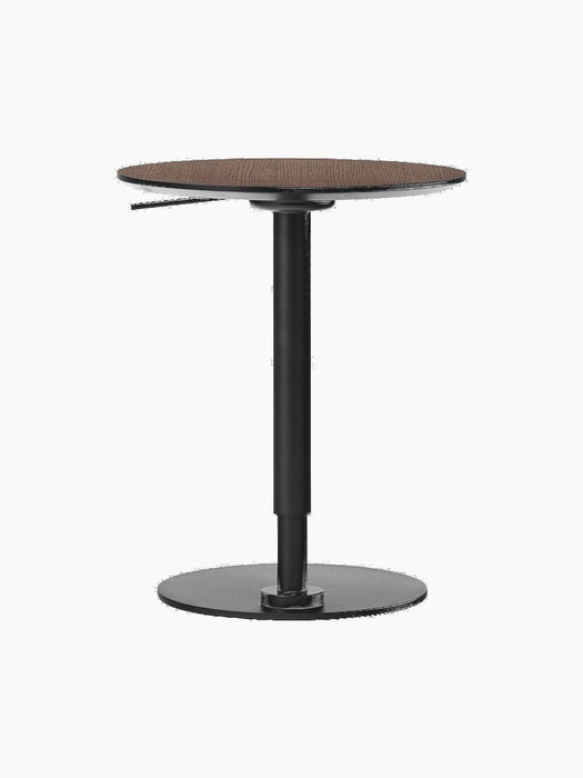 Rear view of the height-adjustable Branch Side Table, featuring a round dark stained oak top and a black steel base.