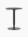 Rear view of the height-adjustable Branch Side Table, featuring a round dark stained oak top and a black steel base.