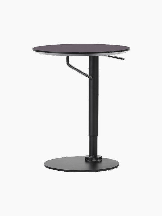 Angled view of the Branch Side Table, featuring a round charcoal linoleum top and a black height-adjustable steel base.
