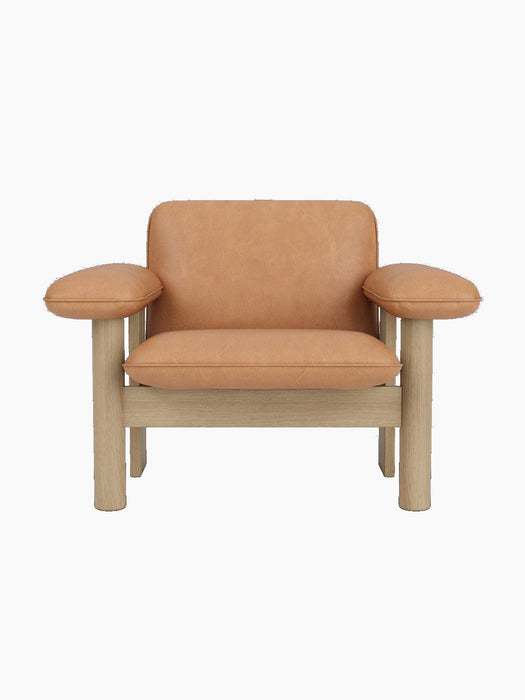 Front view of Brasilia Lounge Chair, Low Back, with a natural oak frame and camel leather upholstery, on a black background.