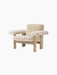 A three-quarter view of the Brasilia Lounge Chair, Low Back, featuring a natural oak frame and plush, off-white sheepskin.