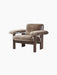 Angled view of the Brasilia Lounge Chair, Low Back, upholstered in plush brown sheepskin with a dark stained wood frame.