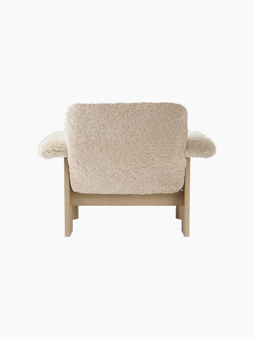 Back view of the Brasilia Lounge Chair with a low back, upholstered in cream sheepskin with a solid natural oak frame.