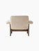 Back view of the Brasilia Lounge Chair, Low Back, in light sheepskin with a dark wooden frame, on a black background.