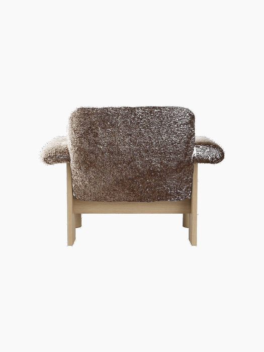 Back view of the Brasilia Lounge Chair with a low back, upholstered in dark brown sheepskin with a natural oak frame.