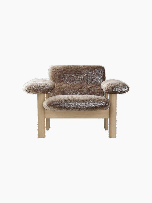 Front view of the Brasilia Lounge Chair, Low Back, with brown sheepskin and a light oak frame on a black background.