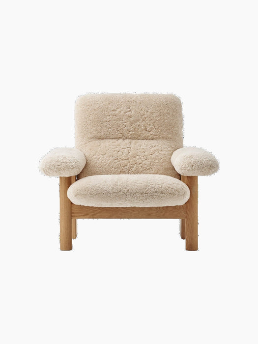 Front view of the Brasilia Lounge Chair. It has a high back, natural oak frame, and thick, comfortable sheepskin upholstery.