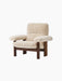 An angled view of the Brasilia Lounge Chair, high back, featuring a dark stained oak frame and plush off-white sheepskin.