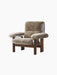 The Brasilia Lounge Chair in brown sheepskin. It has a high back, exaggerated armrests, and a sturdy dark wooden frame.
