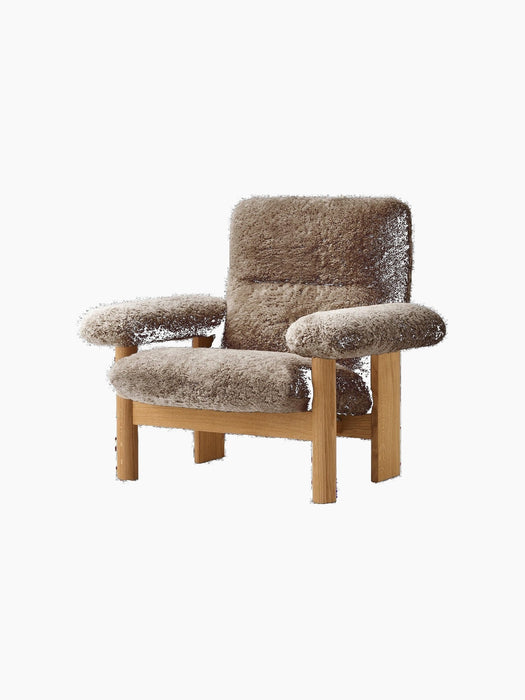 Front-angle view of the Brasilia Lounge Chair with a high back, upholstered in brown sheepskin with a natural oak frame.
