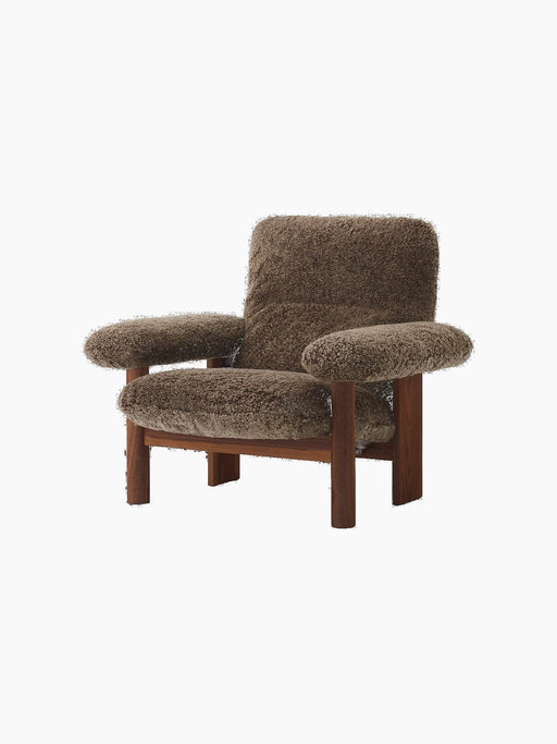 Angled view of the Brasilia Lounge Chair with a walnut frame and plush, deep brown Root sheepskin upholstery.