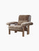 A Brasilia Lounge Chair, High Back, brown sheepskin upholstery, walnut frame, shown from an angle on a black background.