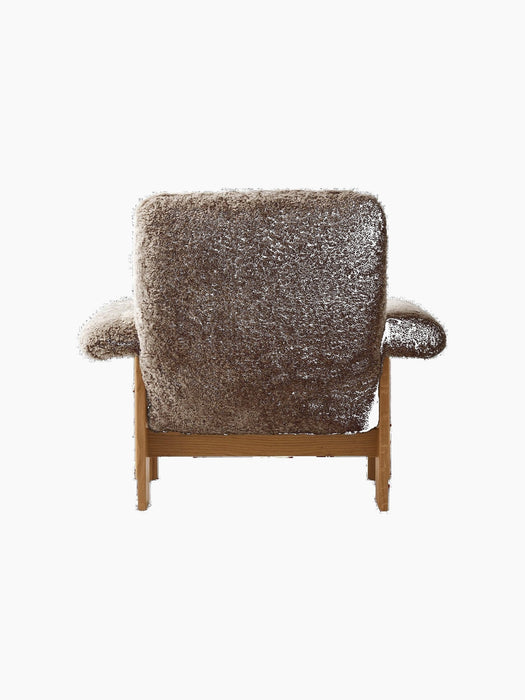 Back view of the Brasilia Lounge Chair. High back and armrests in dark brown sheepskin on a natural oak frame.