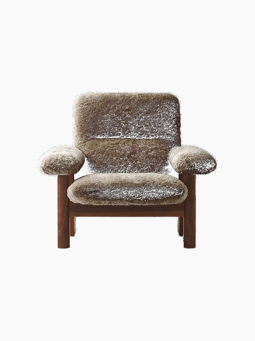 Front-on photograph of the Brasilia Lounge Chair with a high back, upholstered in plush brown sheepskin on a dark oak frame.