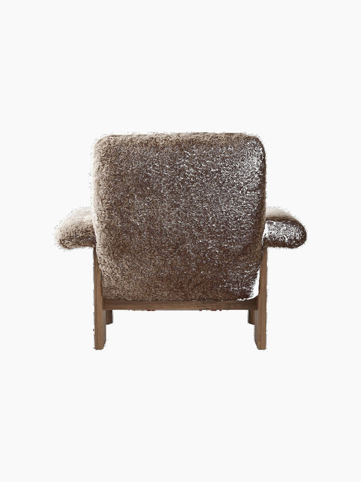 Rear view of the Brasilia Lounge Chair, High Back, in brown sheepskin with a dark walnut frame on a black background.