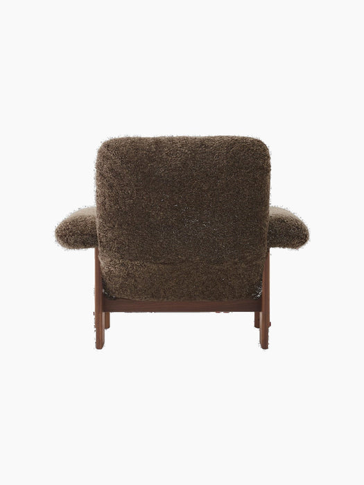 Back view of the Brasilia Lounge Chair, upholstered in fluffy dark brown Sheepskin Root with a dark walnut wood frame.