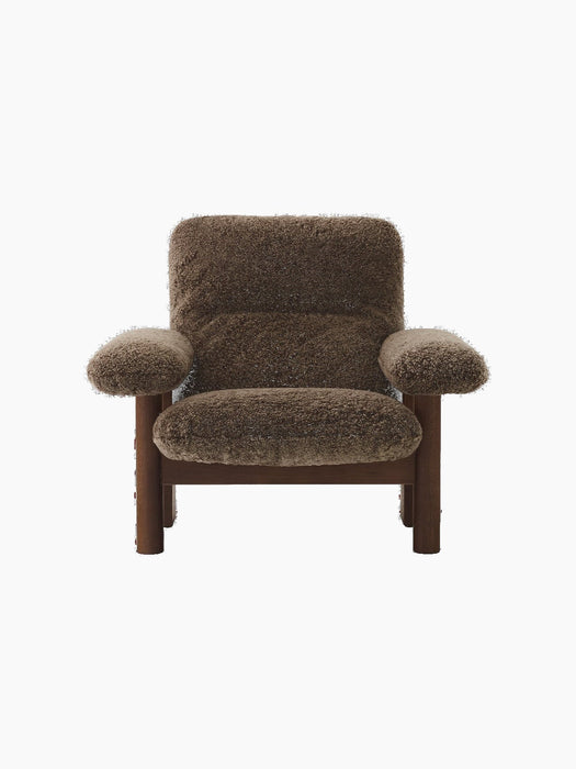 The low-slung Brasilia Lounge Chair seen from the front, with a dark walnut frame and plush, dark brown sheepskin upholstery.