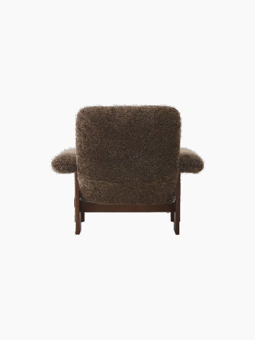 Back view of Brasilia Lounge Chair, high back, upholstered in dark brown Sheepskin Root with a dark stained oak frame.