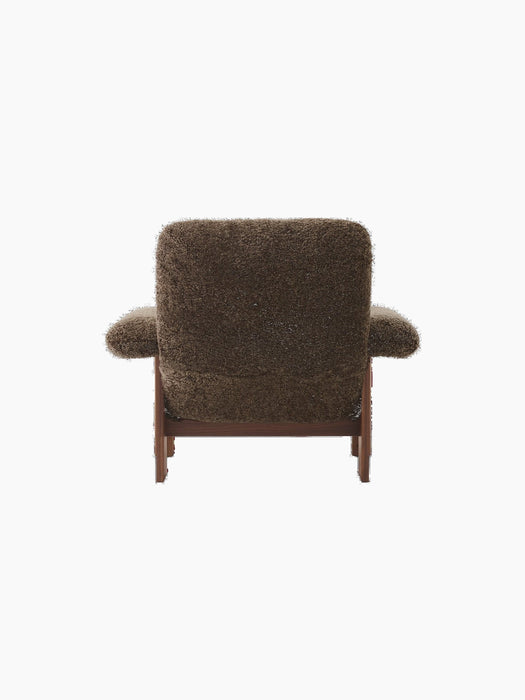 Rear view of the Brasilia Lounge Chair, High Back, upholstered in dark Root sheepskin with a solid walnut frame.