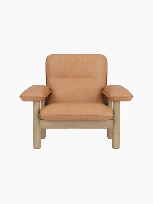 Brasilia Lounge Chair in natural oak and camel leather. A minimalist modern armchair with a sturdy frame and plush cushions.