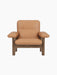Front view of the Brasilia Lounge Chair in walnut with plush, camel leather upholstery, shown against a black background.