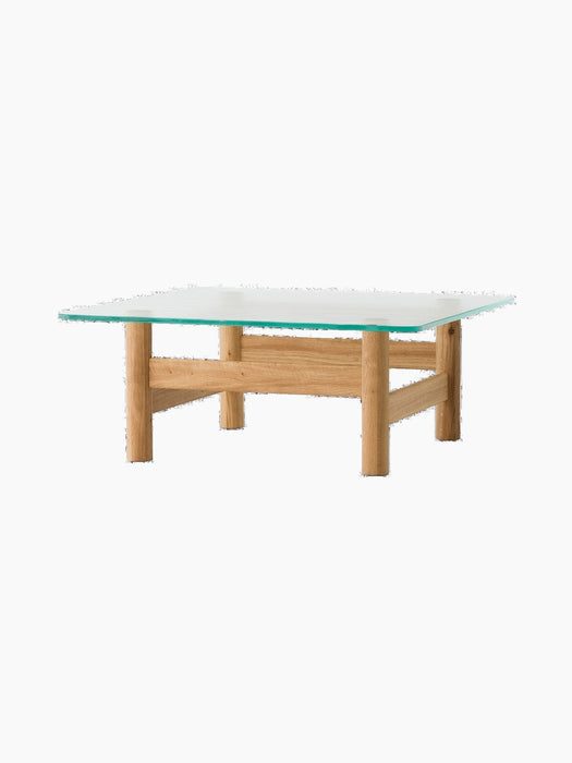 Front view of the Brasilia Lounge Table in natural oak. It has a square glass top on a sturdy base with four round legs.