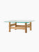 Brasilia Lounge Table, shown from a side angle, with a square glass top and a solid natural oak base on a black background.