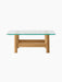 Side view of the Brasilia Lounge Table. It has a thick glass top and a solid natural oak base with four stout, rounded legs.