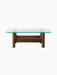 Side view of the Brasilia Lounge Table, featuring a rectangular glass top with rounded corners and a stout, dark wood base.
