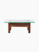 Front view of the Brasilia Lounge Table, showing its solid walnut base and square, tempered glass top on a black background.