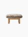 Front view of the Brasilia Ottoman, featuring a plush sheepskin cushion in a natural colour on a natural oak wood frame.