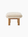 Side view of the Brasilia Ottoman, featuring a Sheepskin Nature cushion on a natural oak frame with robust cylindrical legs.