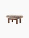 Brasilia Ottoman with a plush 'Root' sheepskin cushion and a dark stained oak frame with four robust, cylindrical legs.