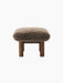 Side view of the Brasilia Ottoman in brown sheepskin, featuring a dark stained oak frame with four robust, cylindrical legs.