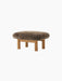 An angled shot of the Brasilia Ottoman, featuring a soft brown sheepskin cushion and natural oak frame with four round legs.