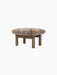 Brasilia Ottoman with a plush sheepskin cushion in a light brown hue, supported by four robust, cylindrical wooden legs.