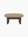 Side view of the Brasilia Ottoman with a dark stained oak frame, robust cylindrical legs and soft Audo Bouclé 02 top.