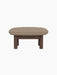 Side view of the Brasilia Ottoman in dark stained oak with a textured Logan Flint textile cushion, on a black background.