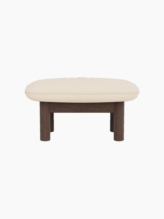 Side view of the Brasilia Ottoman with a dark stained oak frame and a light, textured Logan Jasmine fabric cushion.