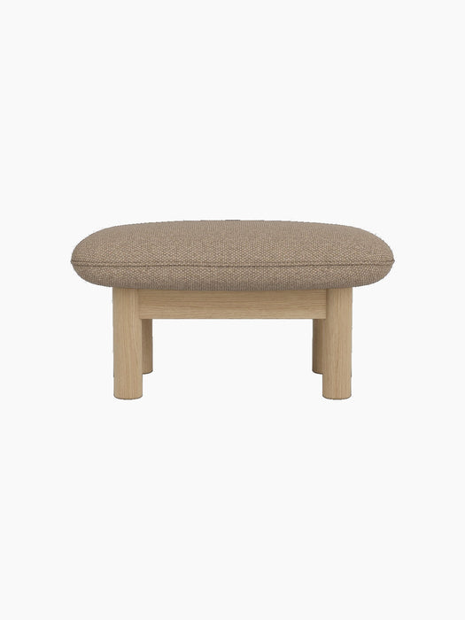 A side view of the Brasilia Ottoman, featuring a textured Logan Flint upholstered cushion and a solid natural oak wood frame.