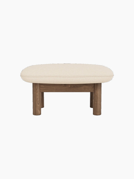Front view of the Brasilia Ottoman, featuring a thick, light-coloured Logan Jasmine textile cushion on a walnut wood frame.