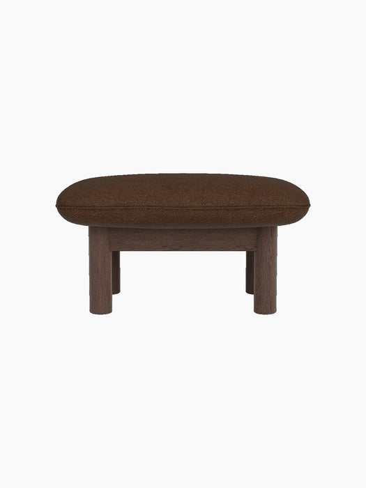 Side view of the Brasilia Ottoman, upholstered in brown Audo Bouclé 07 fabric, with four sturdy dark stained oak legs.