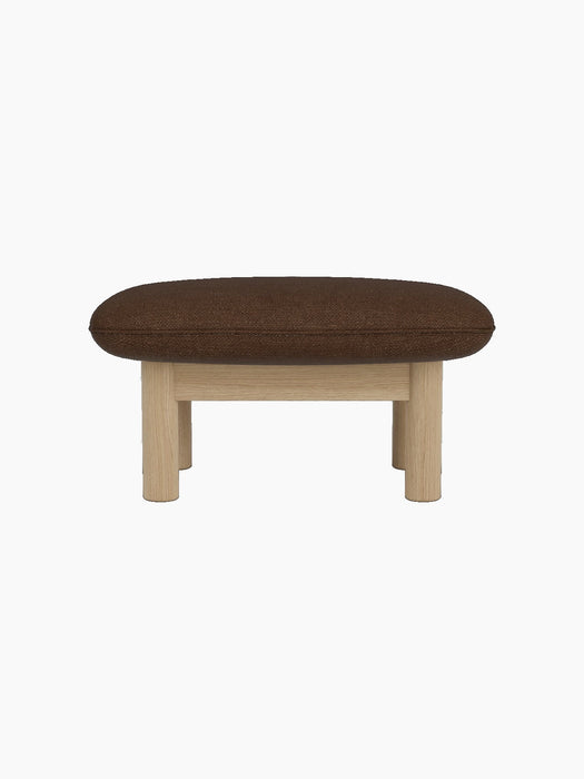 Side profile of the Brasilia Ottoman, upholstered in brown bouclé fabric with a natural oak frame and four cylindrical legs.