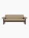 A front view of the Brasilia Sofa, featuring a dark stained oak frame with thick cushions upholstered in Audo Bouclé 02.