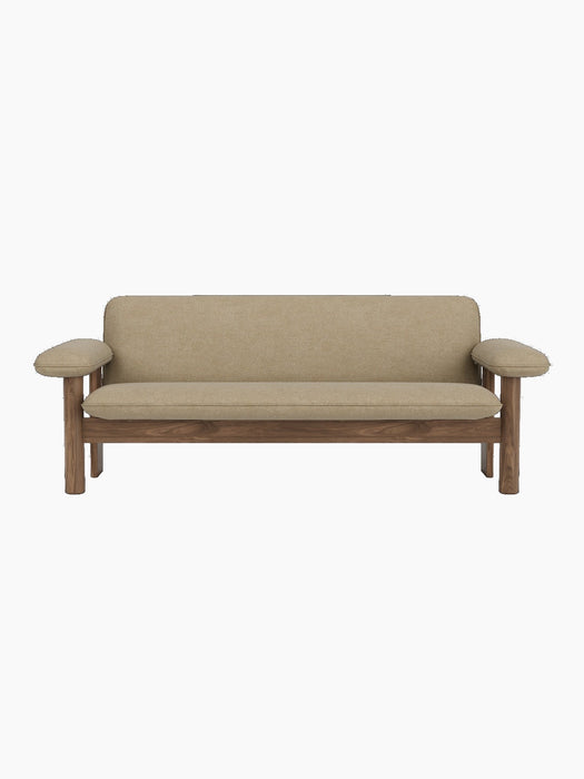 A front-on studio shot of the Brasilia Sofa, featuring a walnut wood frame and beige Audo Bouclé 02 upholstery.