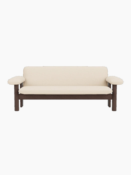 Front view of the Brasilia Sofa, featuring a dark stained oak frame and upholstered in light-coloured Logan Jasmine textile.